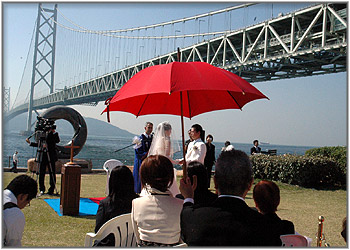 明石海峡大橋に赤いパラソル…相合傘の中の新郎新婦…
